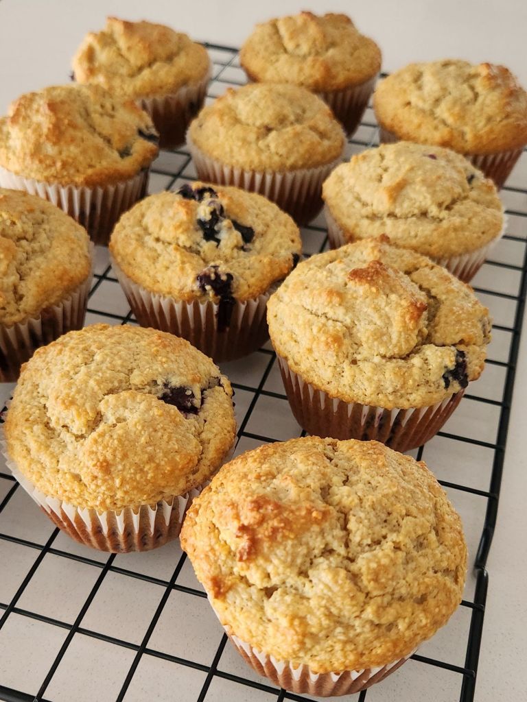 Golden Brown Blueberry Yogurt Muffins cooling o a tray