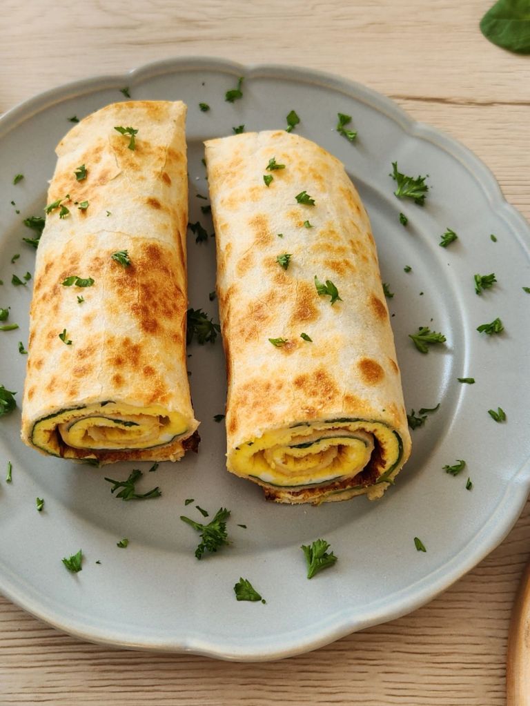 High-Protein tortilla omelette wrap served on a sage green plate