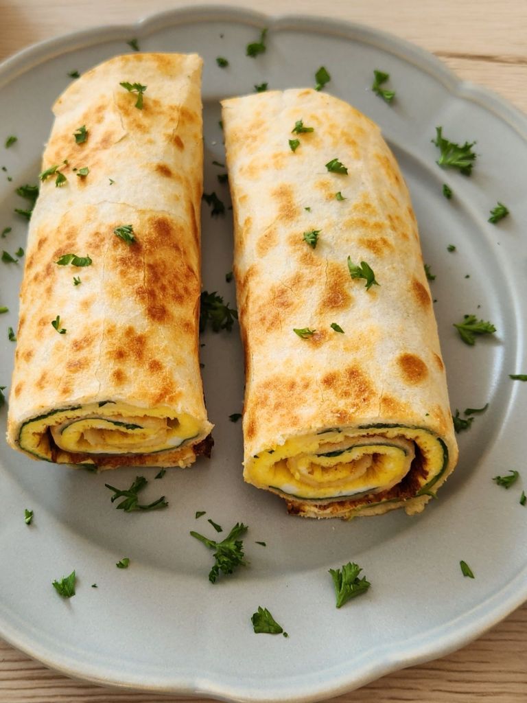 High-Protein tortilla omelette wrap served on a sage green plate