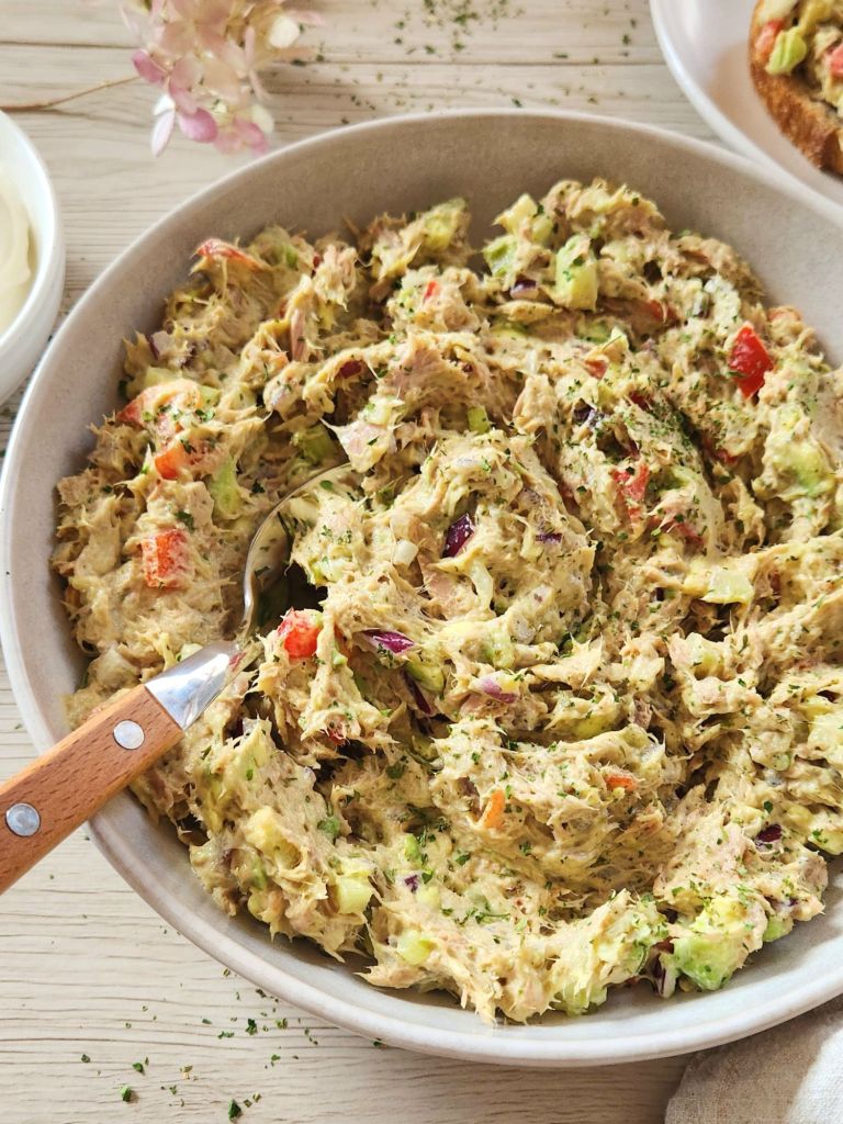 Creamy tuna salad with yogurt, avocado, bell pepper in a beige bowl 
