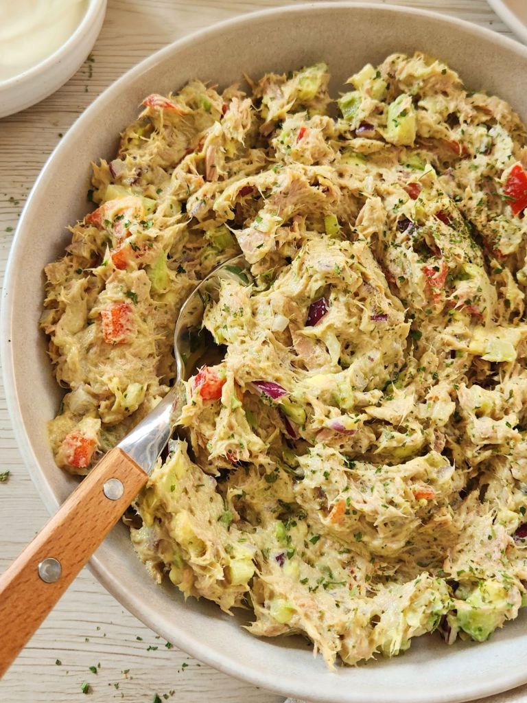 Creamy tuna salad with yogurt, avocado, bell pepper in a beige bowl 