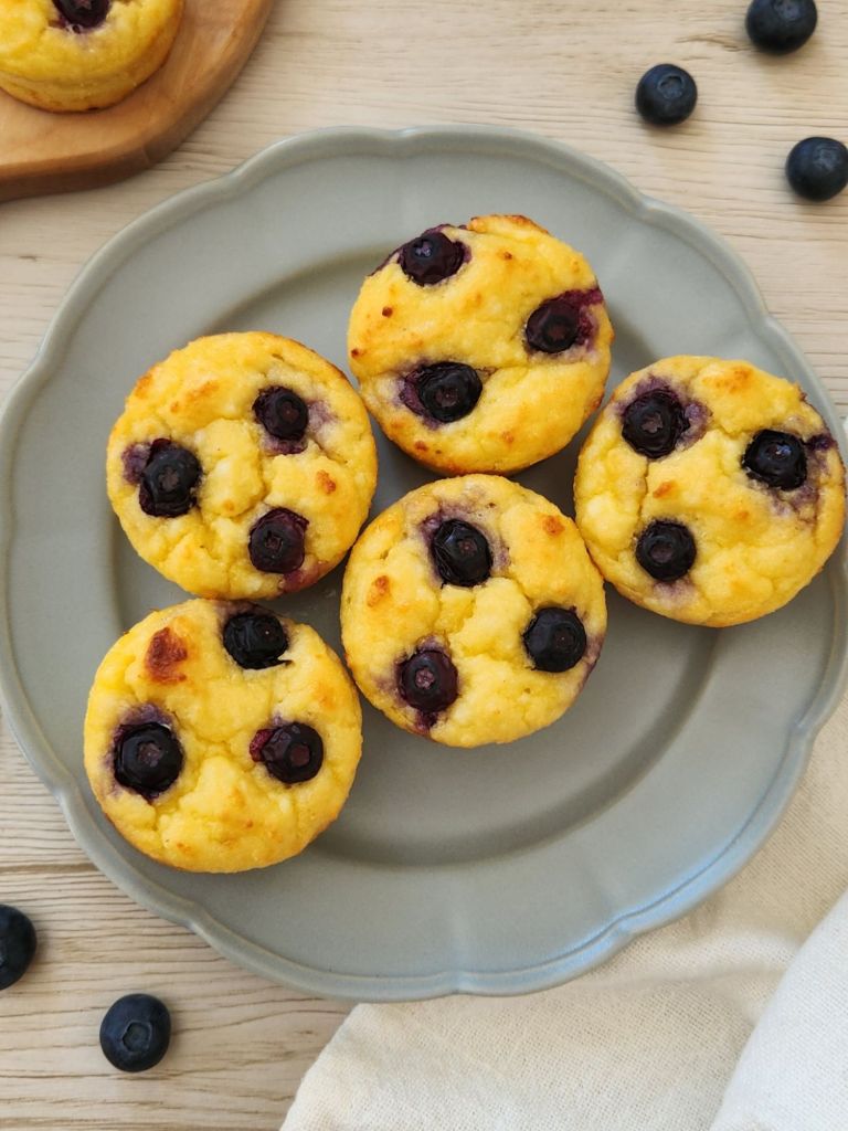 High-protein cottage cheese pancake cups topped with blueberries on sage green plate