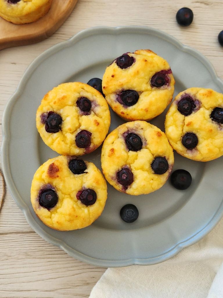 High-protein cottage cheese pancake cups topped with blueberries on sage green plate