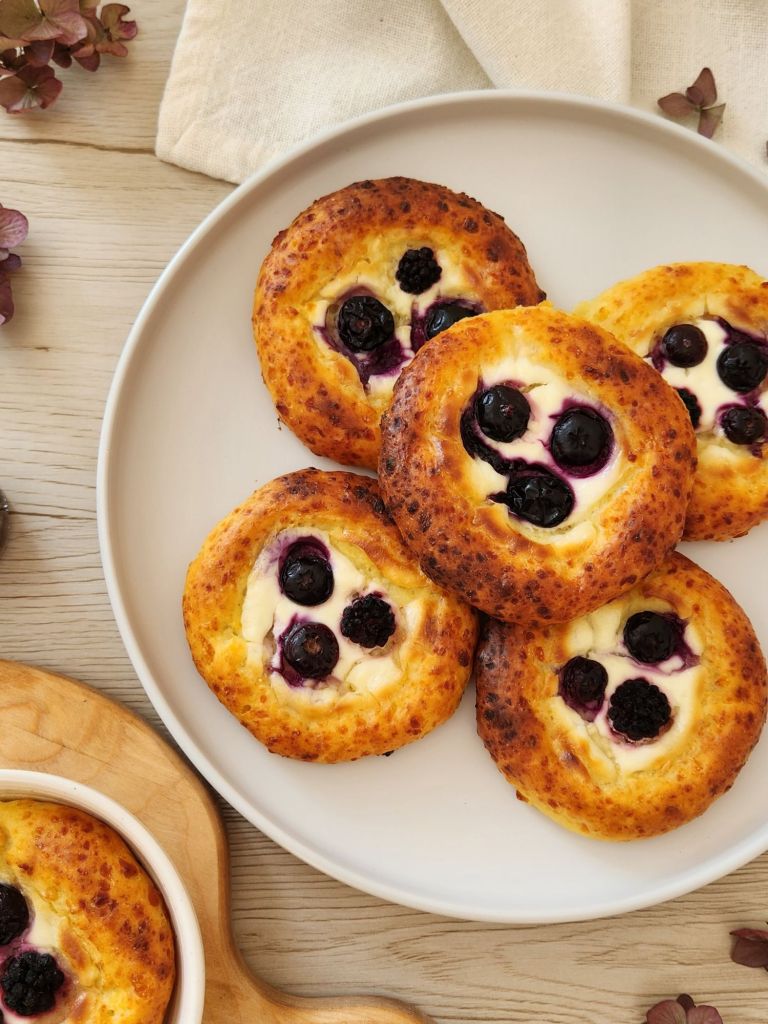 Golden High-Protein Cottage Cheese Brioche Buns stacked on a white plate