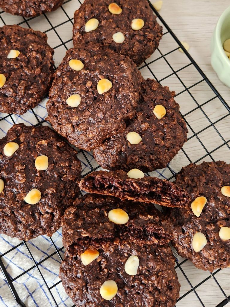 High-protein chocolate oat cookies stacked on rack