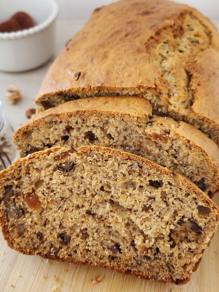 Moist banana bread slices with dried apricots and walnuts close-up
