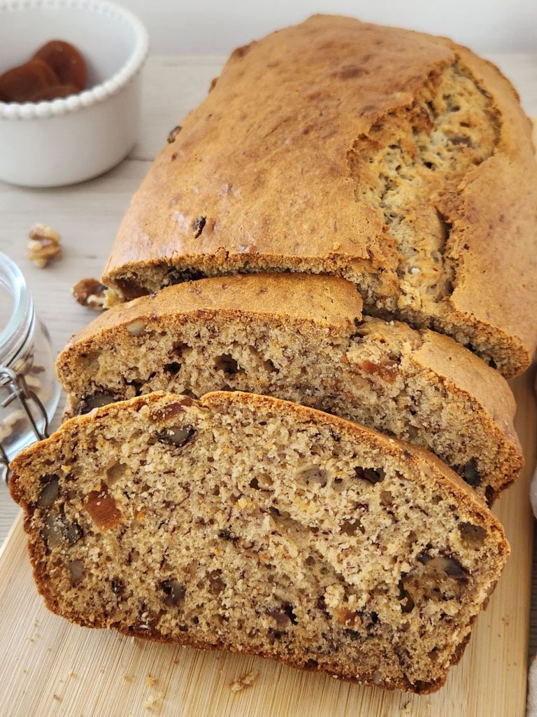 Moist banana bread slices with dried apricots and walnuts close-up