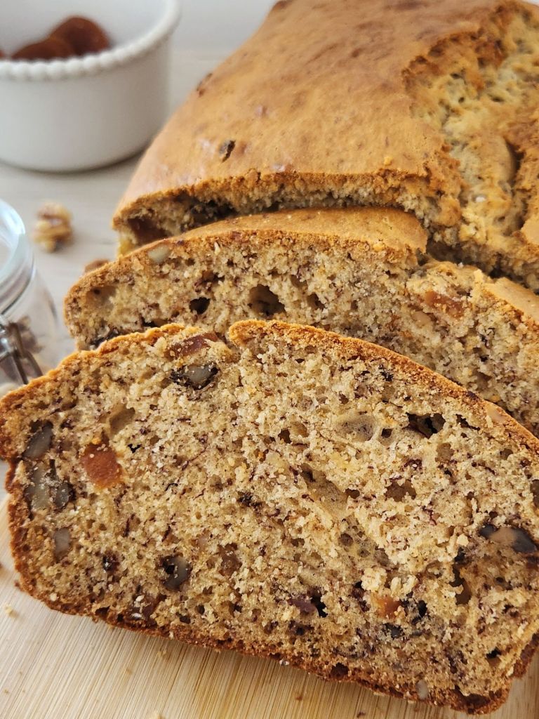 Moist banana bread slices with dried apricots and walnuts close-up
