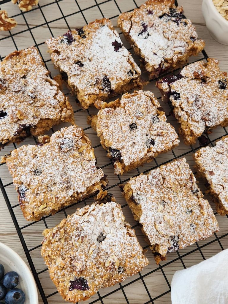Blueberry peanut butter oat bars made with rolled oats and maple syrup on a cooling rack.