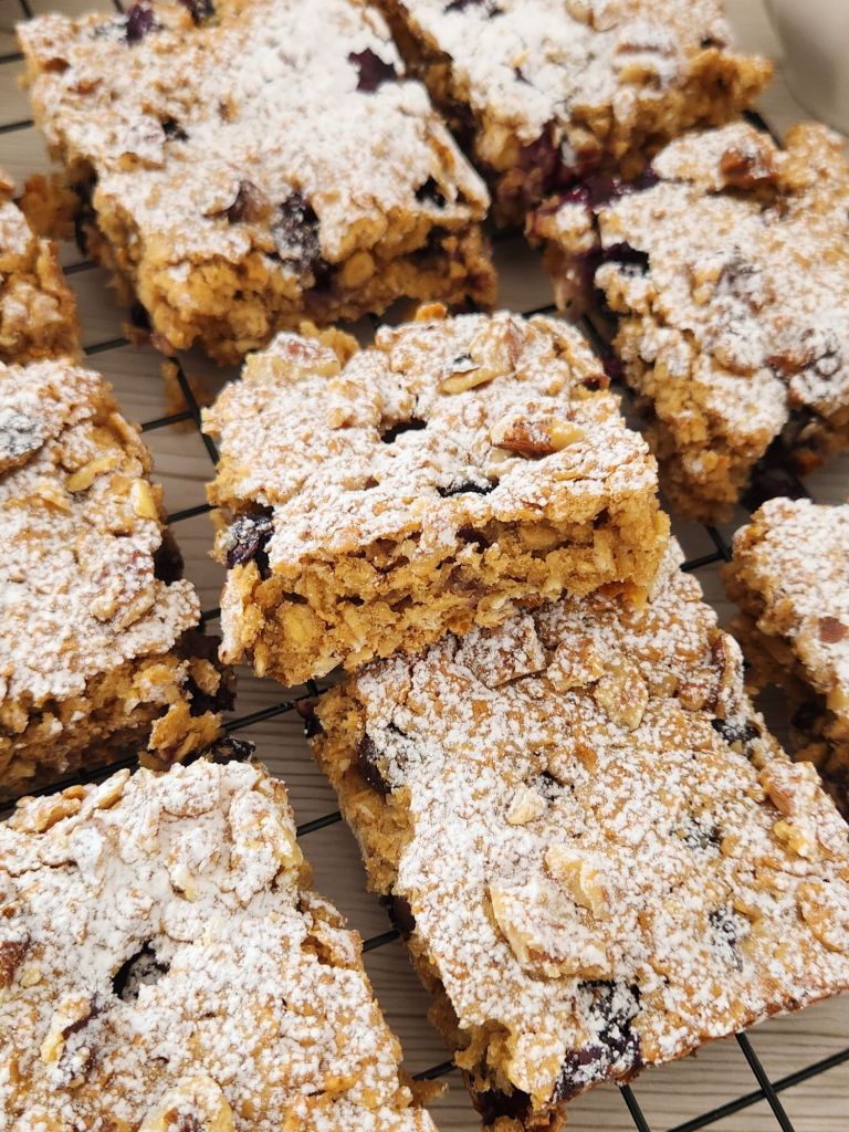 Close-up of blueberry peanut butter oat bars made with rolled oats and maple syrup on a cooling rack.